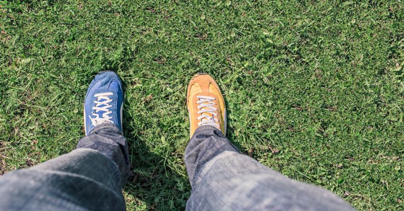 Differences - Person Wearing Unpaired Running Shoes Standing on Green Grass